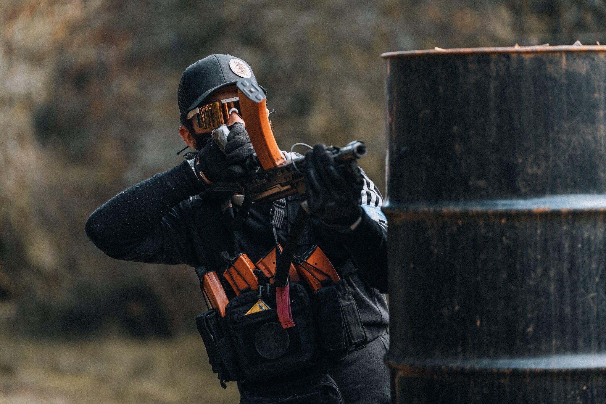 Airsoft player aiming rifle in military gear action shot